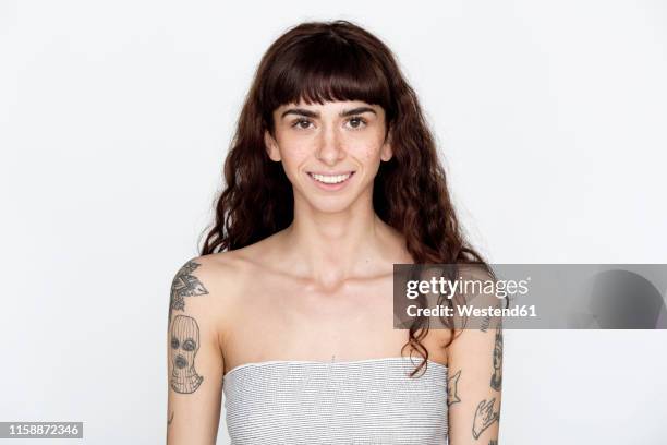 portrait of smiling young woman with freckles and tattoos on her upper arms - bangs bildbanksfoton och bilder