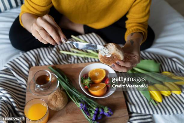 woman sitting on bed, having a healthy breakfast - eating brown bread stock pictures, royalty-free photos & images