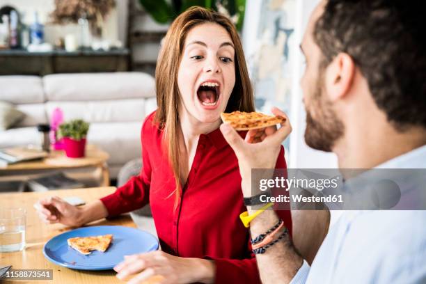 friends having fun, sharing pizza - avidité photos et images de collection