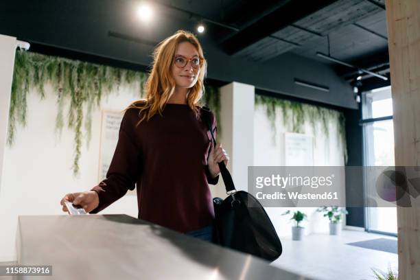young woman entering spa area with chip card - duffle bag stock pictures, royalty-free photos & images