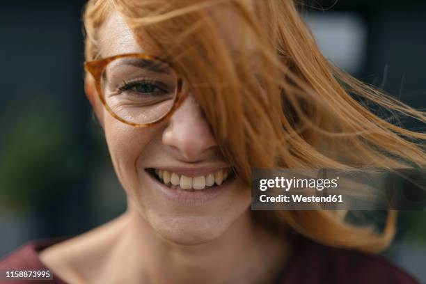 portrait of happy young woman with glasses and windswept hair - gezichtsuitdrukking stockfoto's en -beelden