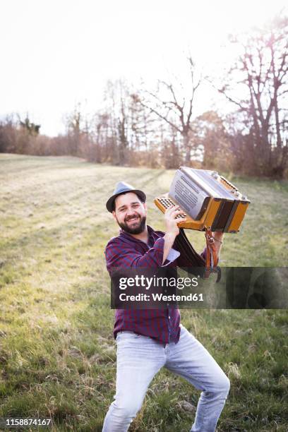 portrait of smiling man with accordion on a meadow - accordionist - fotografias e filmes do acervo