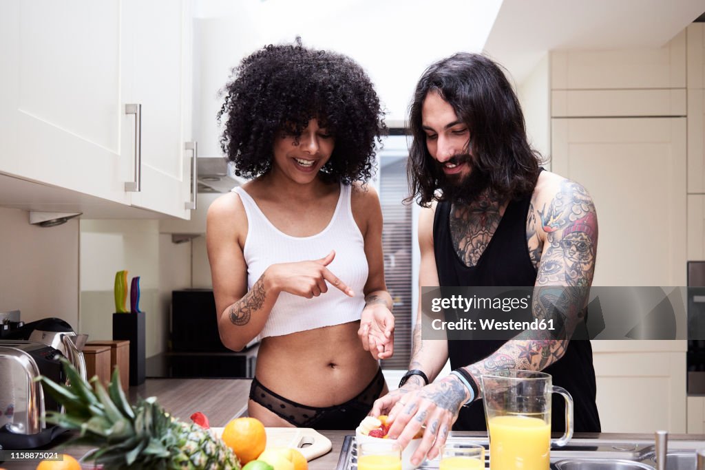 Happy young couple preparing healthy meal in kitchen