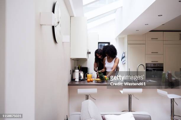 affectionate young couple preparing healthy meal in kitchen - frau in slip stock-fotos und bilder