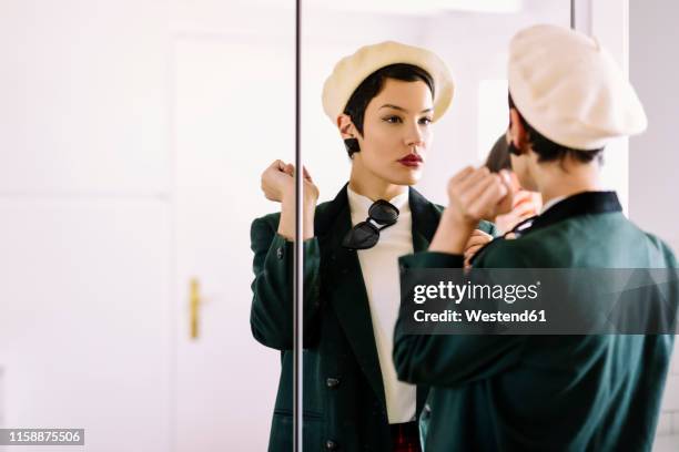 fashionable young woman checking her look in the mirror - beret cap stock pictures, royalty-free photos & images