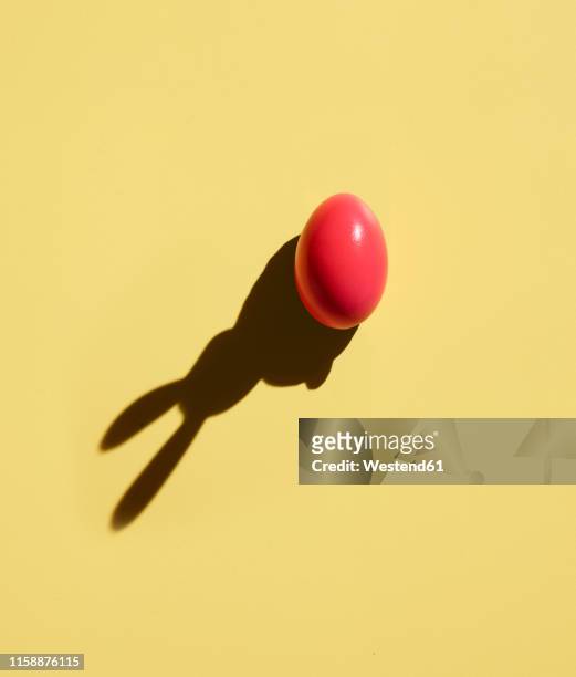 pink easter egg with shadow of bunny ears - easter concept stock pictures, royalty-free photos & images