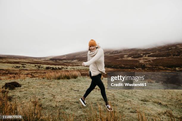 uk, scotland, isle of skye, happy young woman running in rural landscape - insel skye stock-fotos und bilder