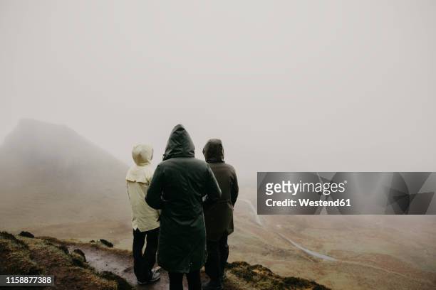 uk, scotland, isle of skye, quiraing viewpoint, rear view of three women in foggy landscape - highlands schottland wandern stock-fotos und bilder