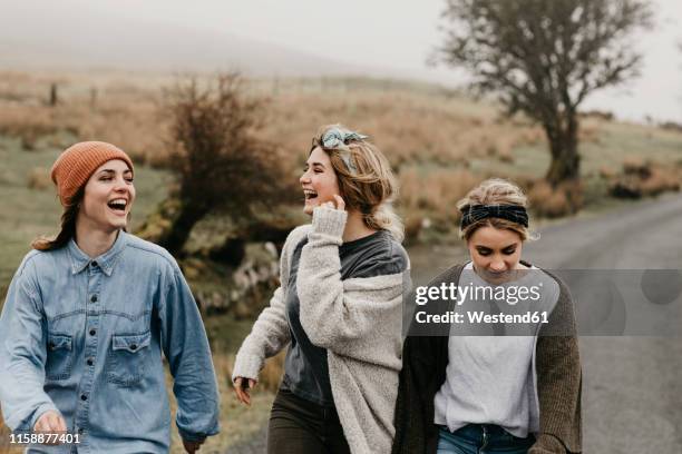 uk, scotland, isle of skye, three happy young woman on a rural road - scottish highlands stock pictures, royalty-free photos & images