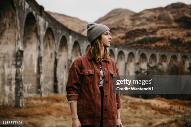 uk, scotland, highland, portrait of young woman at glenfinnan viaduct - glenfinnan viaduct stock pictures, royalty-free photos & images