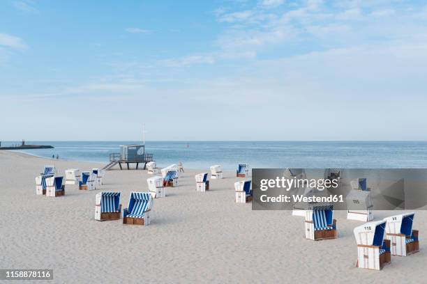 germany, sylt, north sea, sandy beach with hooded beach chairs - isla de sylt fotografías e imágenes de stock