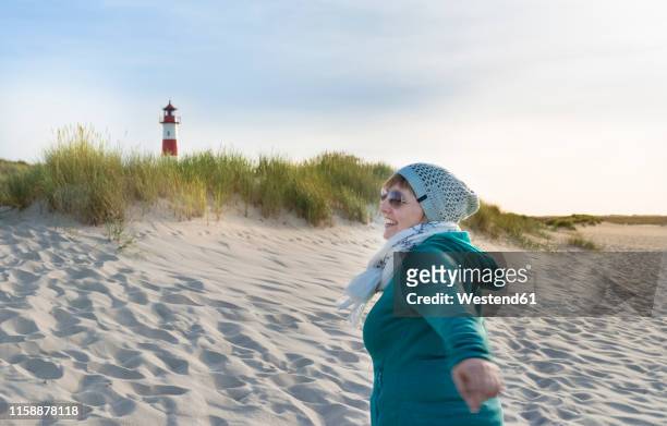 germany, sylt, north sea, woman strolling on sandy beach - ellenbogen stock pictures, royalty-free photos & images