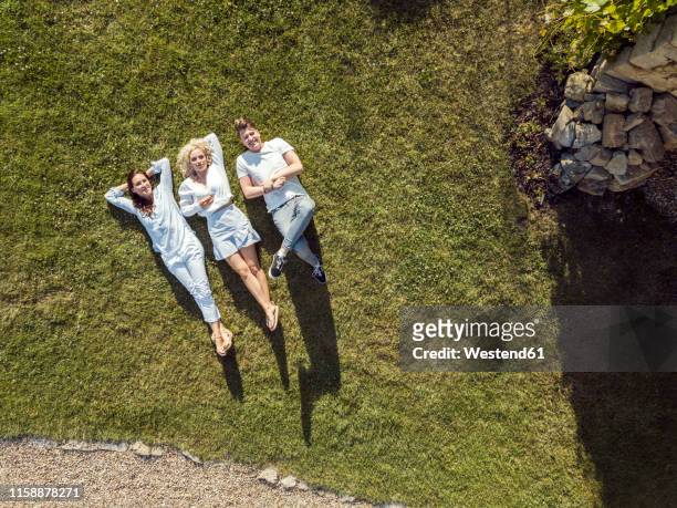 friends relaxing on the grass in summer - reclining stock pictures, royalty-free photos & images