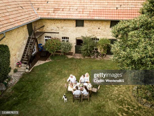 family eating together in the garden in summer - bauernhaus stock-fotos und bilder