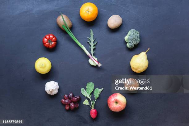 fruits and vegetables buliding clock on dark ground - circle gala stock pictures, royalty-free photos & images