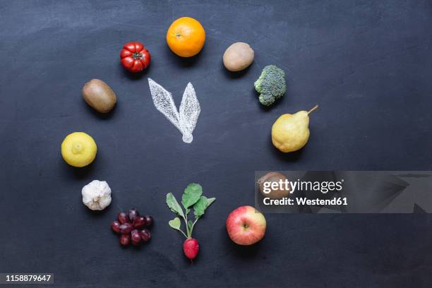 fruits and vegetables buliding clock on dark ground with - arranging stock-fotos und bilder