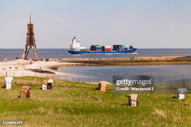 germany, lower saxony, cuxhaven, north sea, ball beacon at beach, hooded beach chairs, container ship - cuxhaven stockfoto's en -beelden