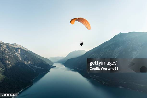 austria, tyrol, paraglider over lake achensee in the early morning - parachute stock-fotos und bilder