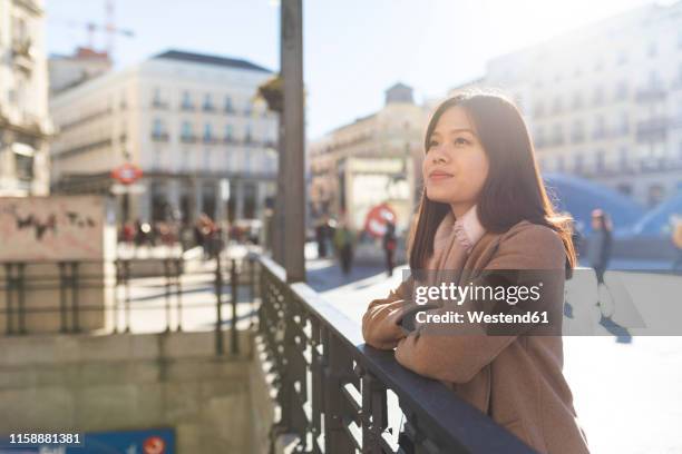 spain, madrid, smiling young woman at puerta del sol looking around - puerta de sol stock-fotos und bilder