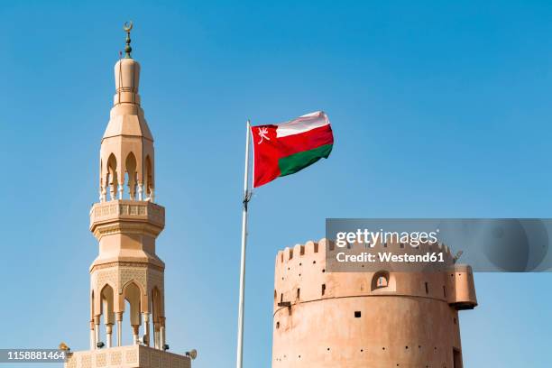 sultanate of oman, ras al hadd, ras al hadd castle with omani flag and minaret - omani flag stock pictures, royalty-free photos & images