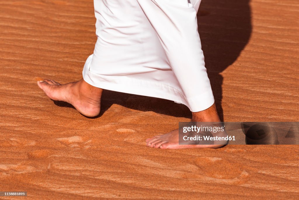 Bedouin walking in the desert, Wahiba Sands, oman