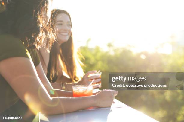 aantrekkelijke levendige vrouwen bij zonsondergang genieten en een stedelijke omgeving met cocktails - hair color saloon stockfoto's en -beelden