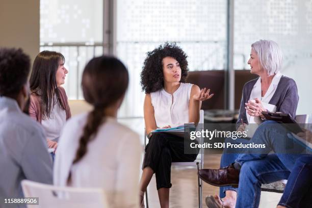 la donna adulta media spiega il suo problema durante la sessione di terapia di gruppo - organizations foto e immagini stock