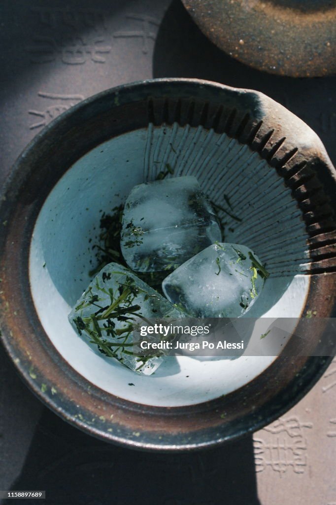 Ice cubes melting on Kukicha green tea leaves