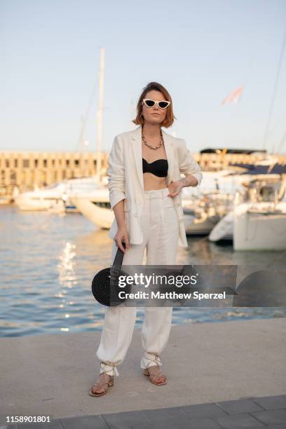 Guest is seen on the street attending 080 Barcelona Fashion Week wearing linen white blazer and pants with black bag and sunglas on June 28, 2019 in...