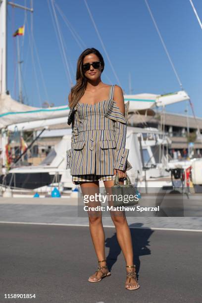 Guest is seen on the street attending 080 Barcelona Fashion Week wearing grey striped dress with olive bag and sandals on June 28, 2019 in Barcelona,...