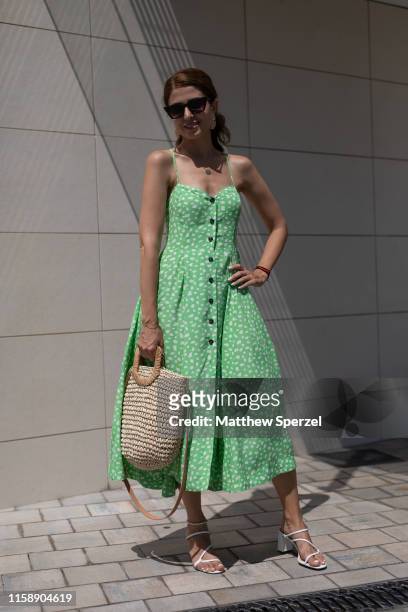 Guest is seen on the street attending 080 Barcelona Fashion Week wearing green dress with straw bag and white on June 28, 2019 in Barcelona, Spain.
