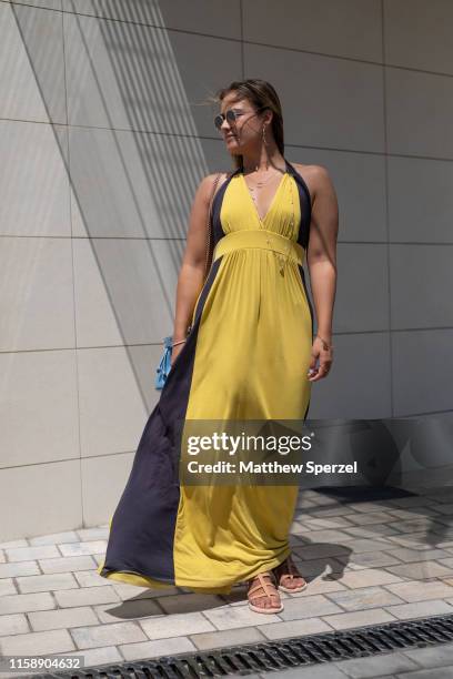 Guest is seen on the street attending 080 Barcelona Fashion Week wearing yellow/black dress, blue bag on June 28, 2019 in Barcelona, Spain.