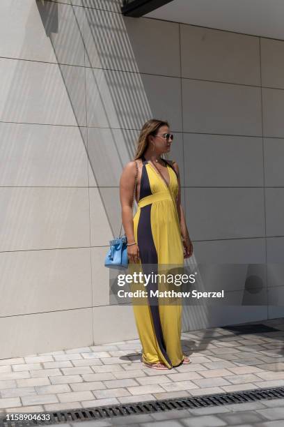 Guest is seen on the street attending 080 Barcelona Fashion Week wearing yellow/black dress, blue bag on June 28, 2019 in Barcelona, Spain.