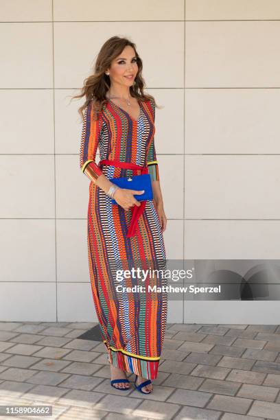 Guest is seen on the street attending 080 Barcelona Fashion Week wearing colorful stripe dress, blue bag on June 28, 2019 in Barcelona, Spain.