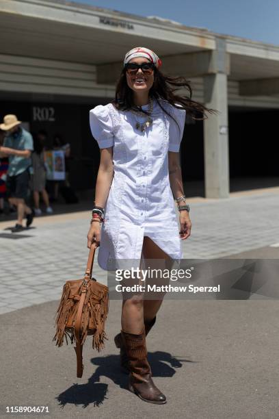 Guest is seen on the street attending 080 Barcelona Fashion Week wearing white dress, brown cowgirl boots and light brown fringe leather bag with...