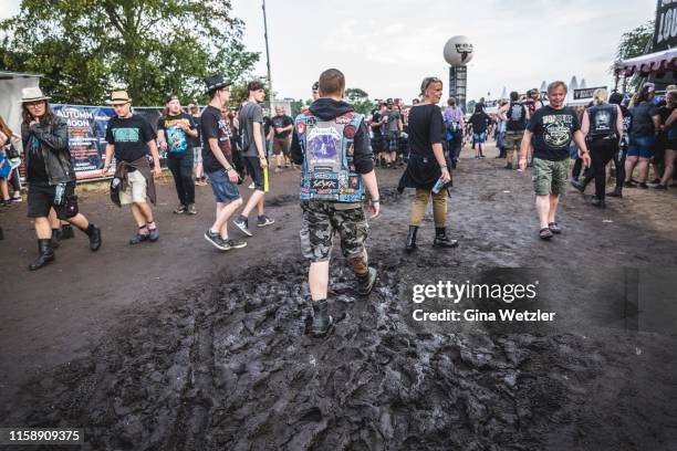 Festival visitor walking through the mud during the Wacken Open Air festival on August 1, 2018 in Wacken, Germany. Wacken is a village in northern...