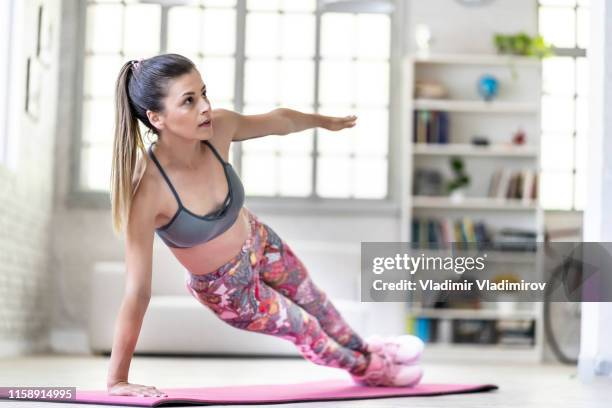 young woman exercising at home, side plank pose - side plank pose stock pictures, royalty-free photos & images