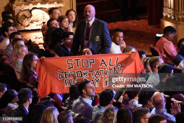 Protester unfurls a banner as Democratic presidential hopefuls participate in the second round of the second Democratic primary debate of the 2020...