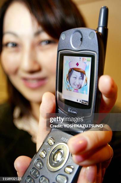 Japan's mobile communication giant NTT DoCoMo employee Mamiko Tanaka displays the company's latest mobile phone "Mova N251iS" equiped with a...