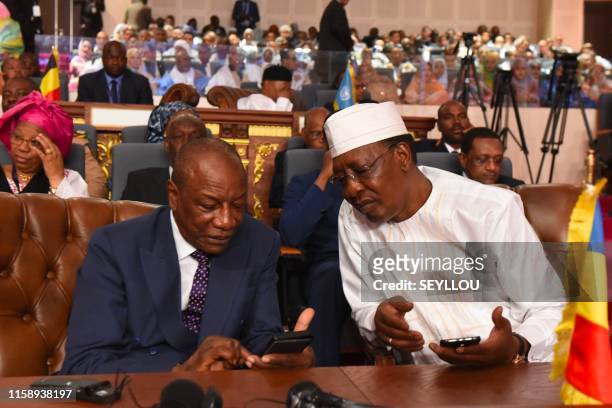 Guinean President and Chairman of the African Union Alpha Conde speaks with Tchadian president Idriss Deby during the newly elected Mauritania's...
