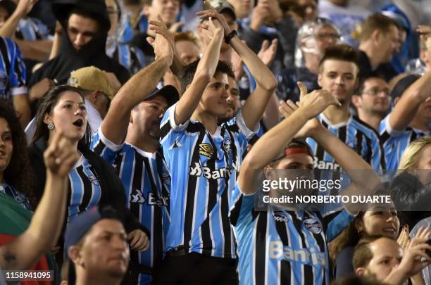 Fans of Brazil's Gremio cheer for their team before the start of theCopa Libertadores football match at the Defensores del Chaco stadium in Asuncion...
