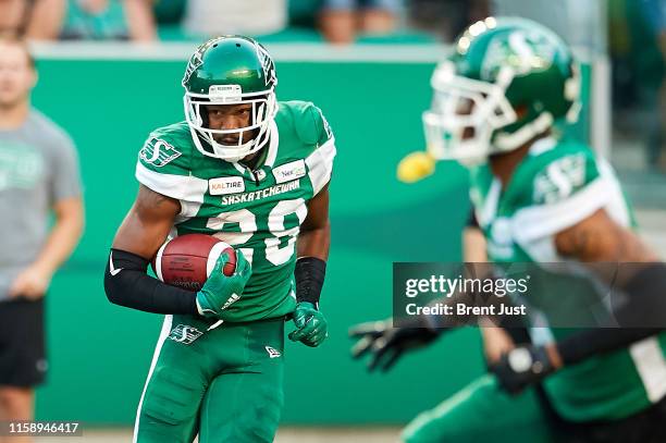 Loucheiz Purifoy of the Saskatchewan Roughriders runs with the ball after making an interception in the first half of the game between the Hamiton...