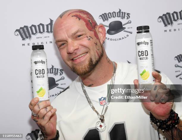 Singer Ivan Moody of Five Finger Death Punch displays CBD water bottles during an appearance to celebrate the release of Moody's Medicinals, his new...