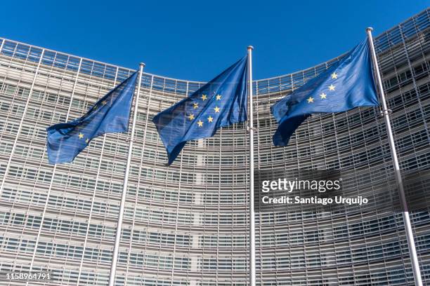 european union flags at berlaymont building of the european commission - european commission stock-fotos und bilder