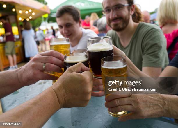 Beer festival in Bonn. Hands with full beer glasses.