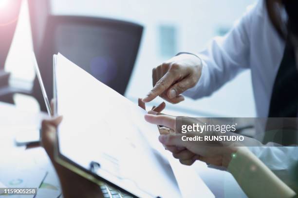 close up of business people reviewing financial data in meeting - 研究 ストックフォトと画像