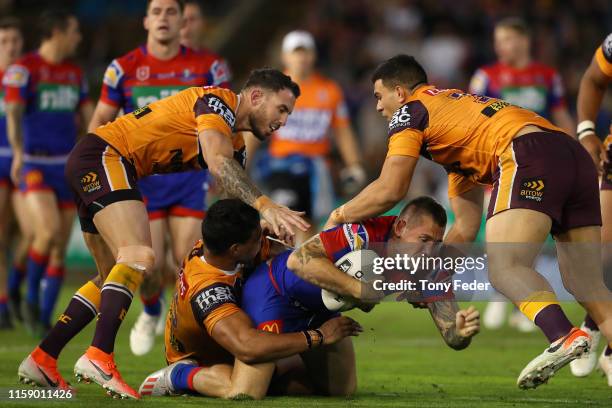 Shaun Kenny-Dowall of the Newcastle Knights is tackled during the round 15 NRL match between the Newcastle Knights and the Brisbane Broncos at...