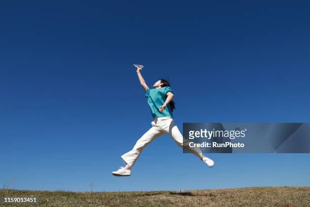 nurse jumping with paper airplane - doctor leaping stock pictures, royalty-free photos & images