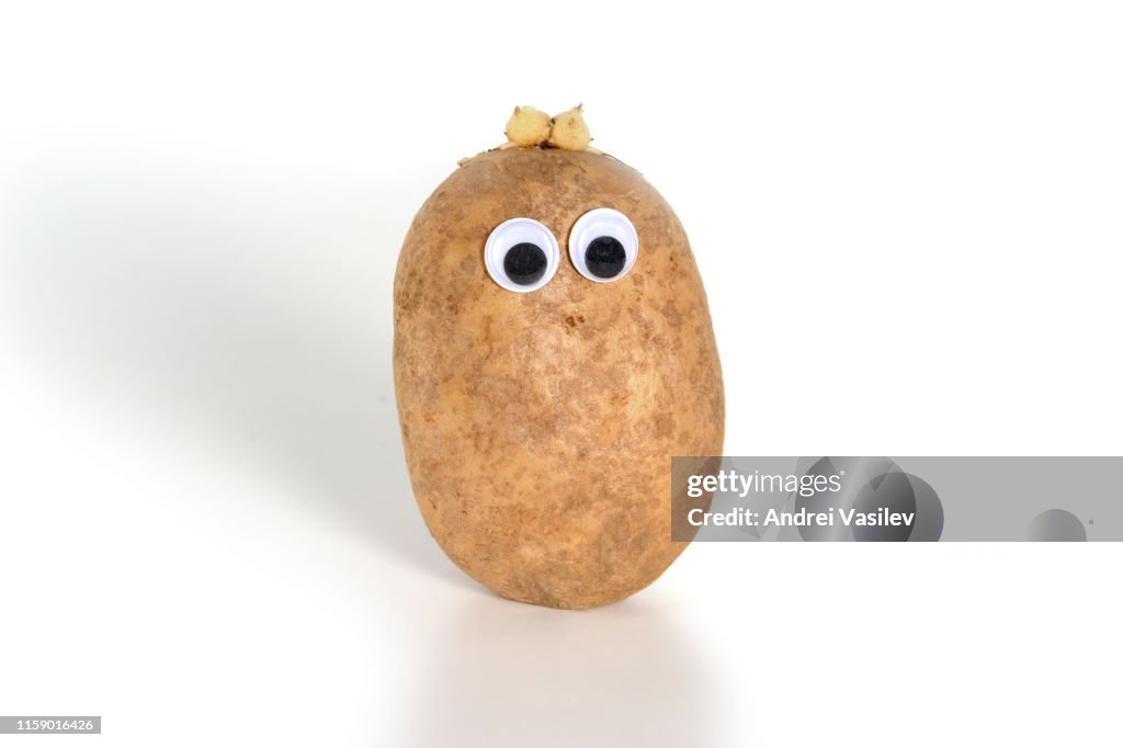 Googly eyes. Funny cute brown mister Fresh Potato, on white background.