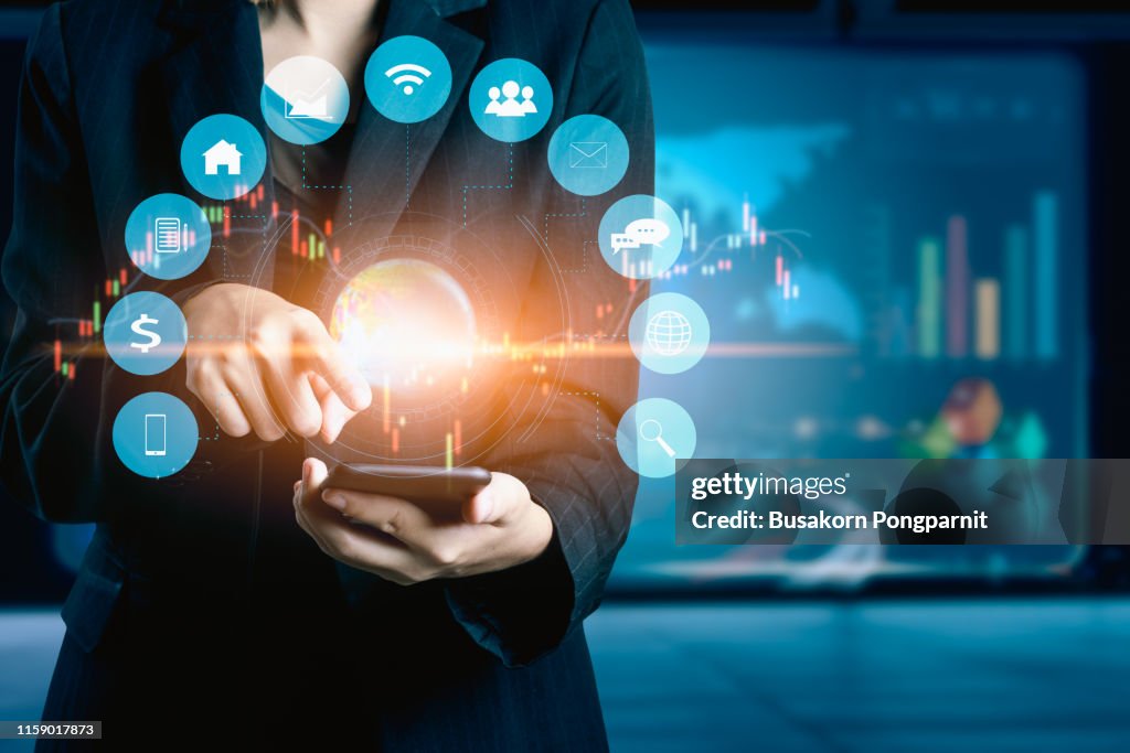 Businesswomen using mobile phone analyzing data and economic growth graph chart. Technology digital marketing and network connection.